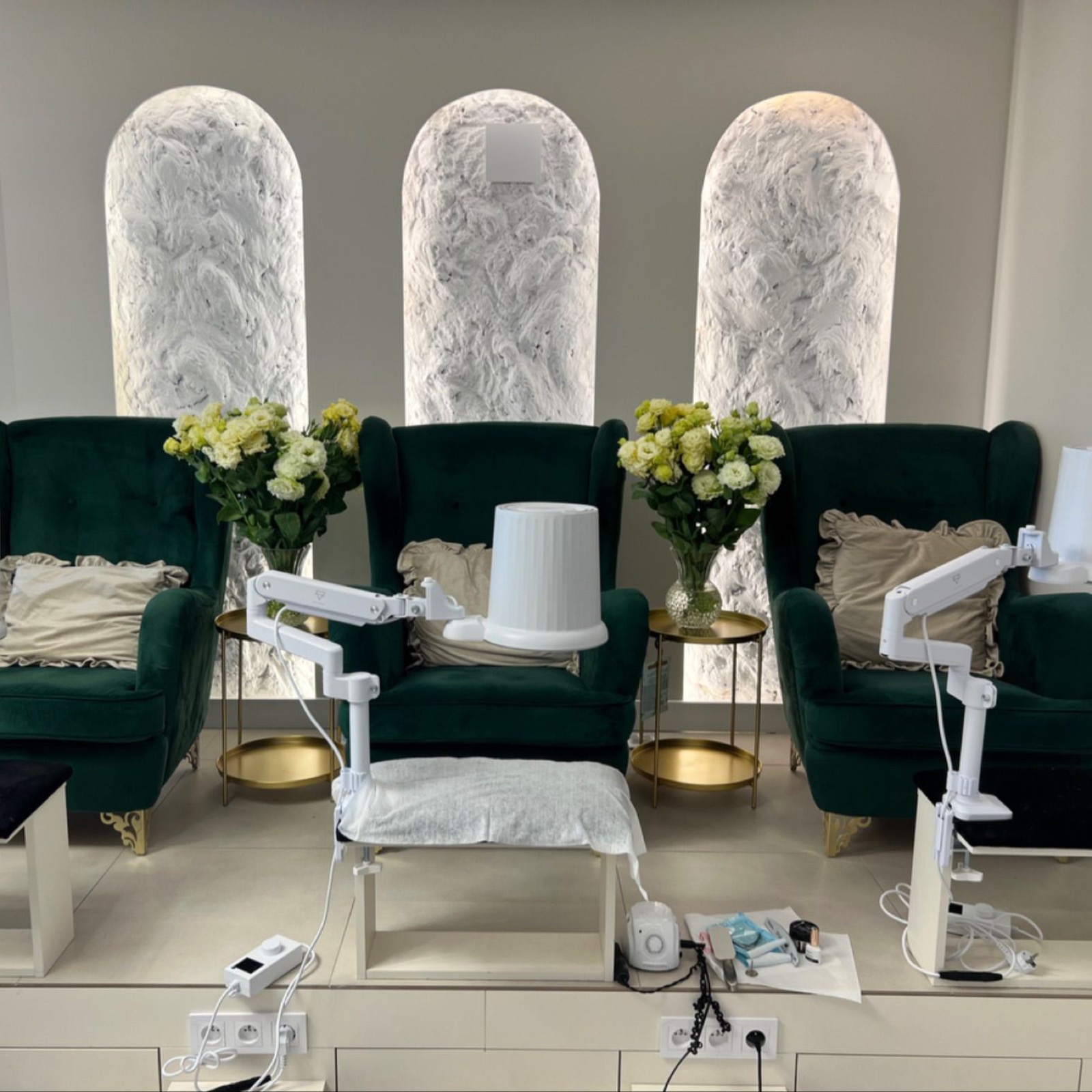 Wnętrze salonu Just Beauty: zielone fotele przy stanowiskach do manicure